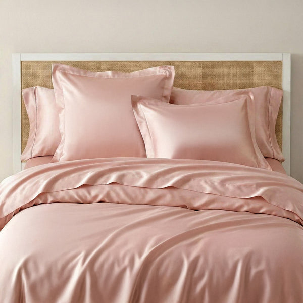 Pink bedding set on a bed with a woven headboard.